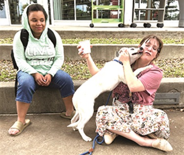 Library Tales and Tails event participants loving on a shelter dog.